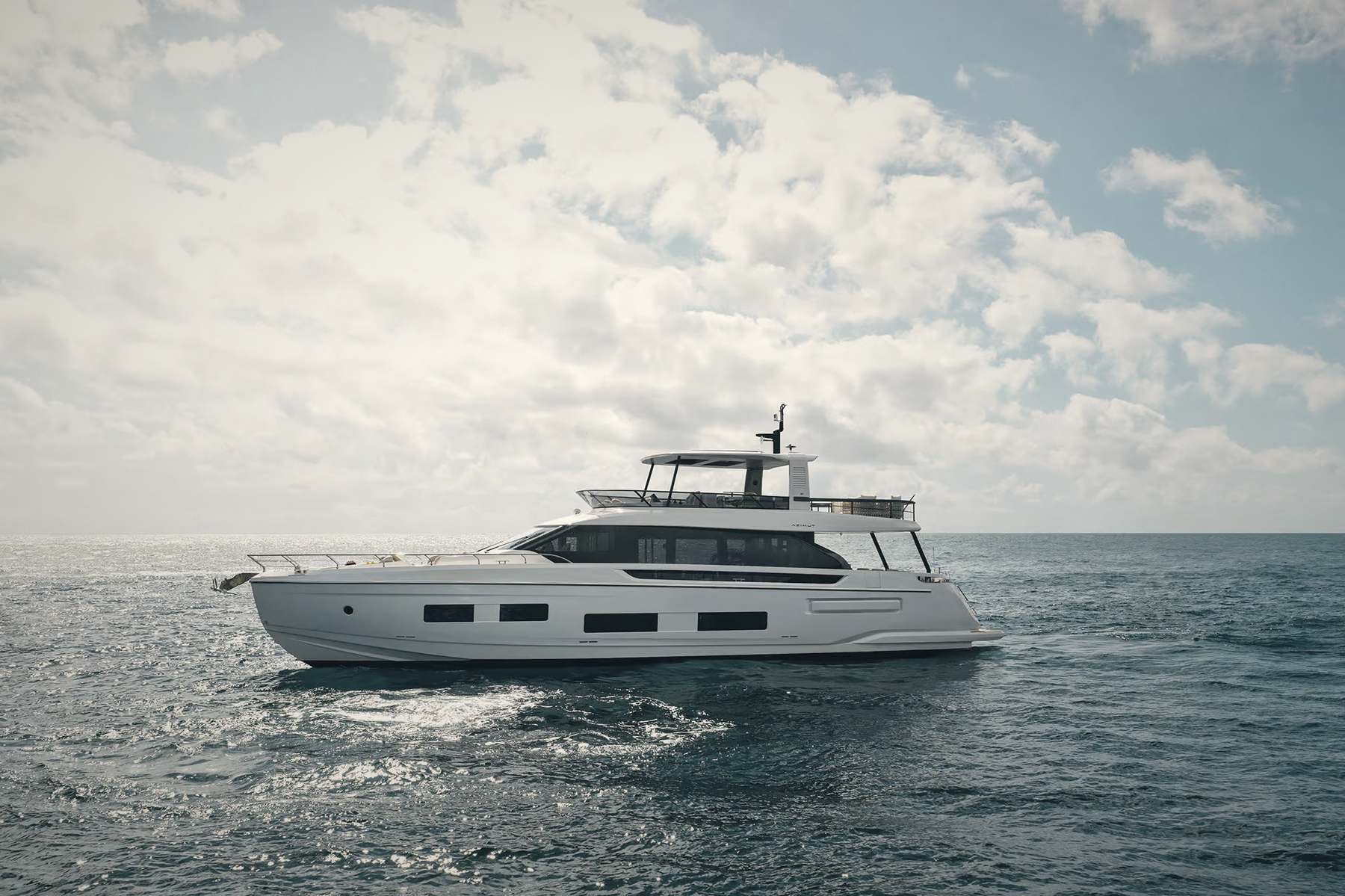 A flybridge motor yacht lying on open water