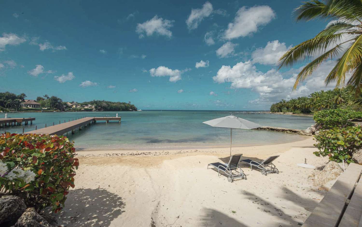 A small cove, the dock and two chairs under an umbrella