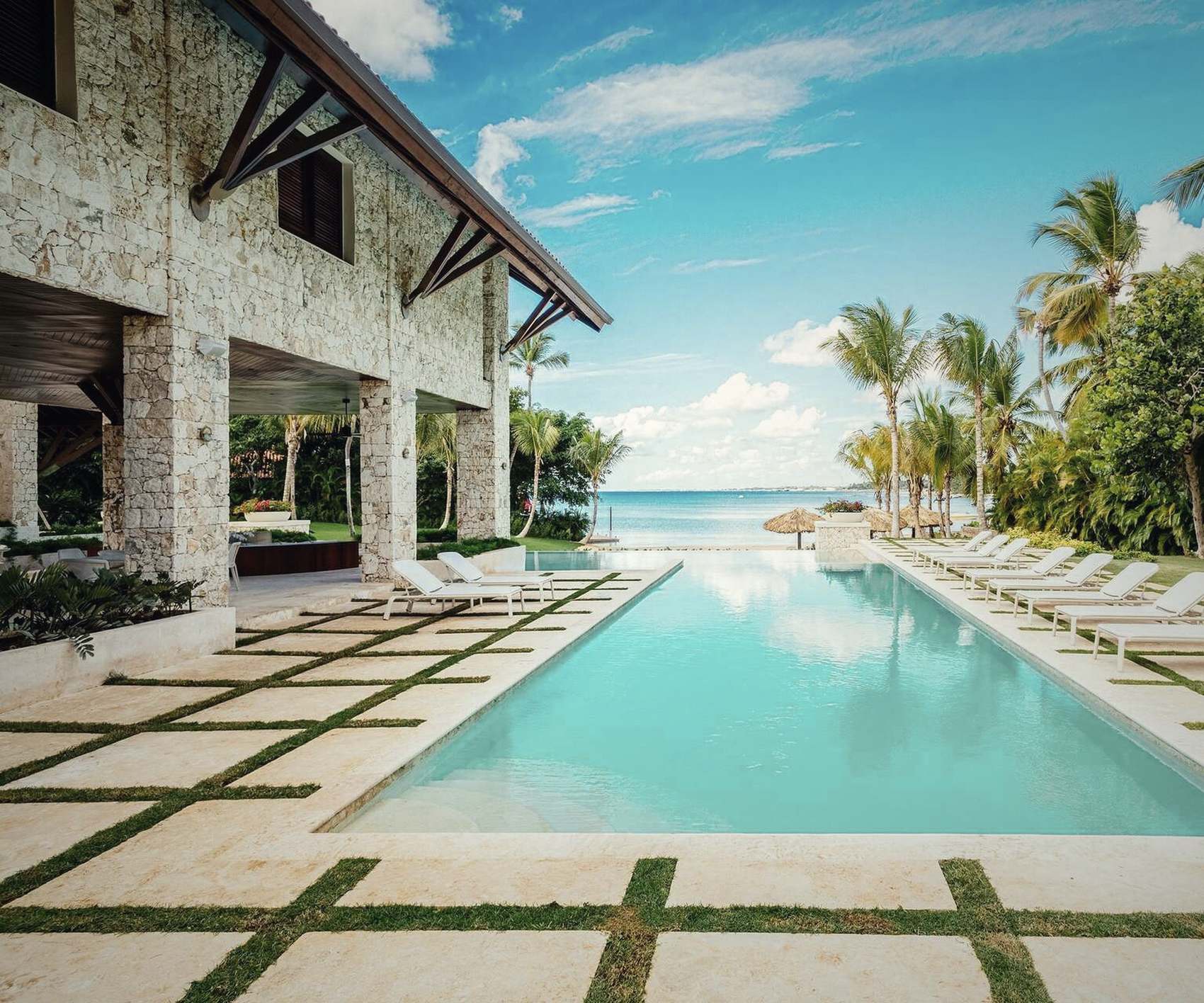 A coral stone house on the water, its pool running toward the sea